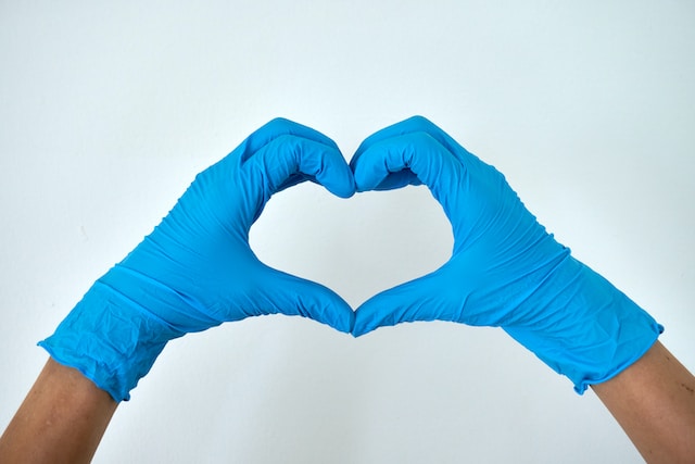 Small round picture of a heart made with fingers.