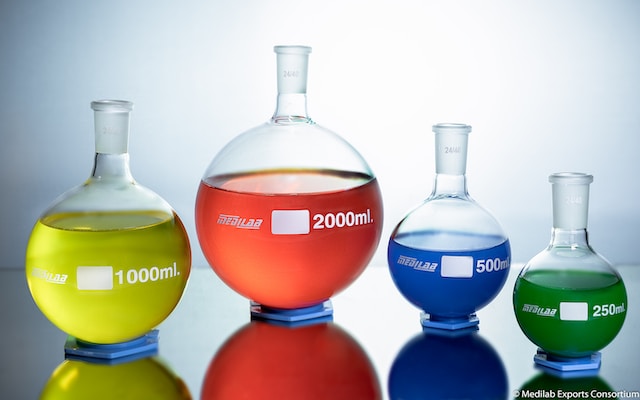 Small round picture of lab flasks with fluids of diferent colors